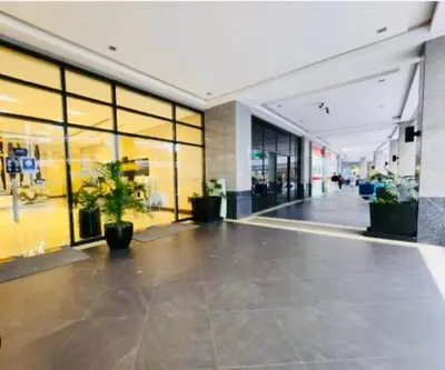 an empty lobby with potted plants in a building at Enter Home McKinley with a View in Manila