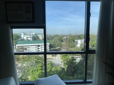 a window with a view of a city at Enter Home McKinley with a View in Manila