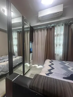 a bedroom with a bed and a large mirror at Sea Residences Tower A 7th floor facing pool by Richnells your cozy oasis in Manila