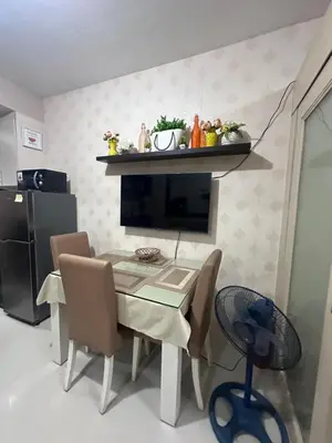 a dining room with a table and chairs and a fireplace at Sea Residences Tower A 7th floor facing pool by Richnells your cozy oasis in Manila