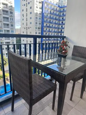 a table and two chairs on a balcony with a view at Sea Residences Tower A 7th floor facing pool by Richnells your cozy oasis in Manila