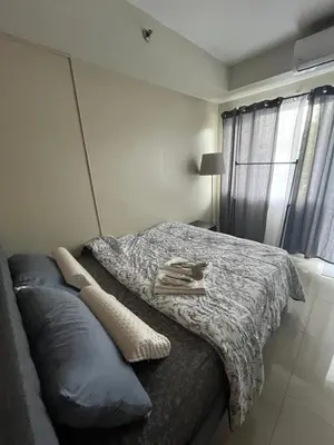 a bedroom with a bed and a couch at Adrianne Condotel at Shell Residences Condominium, MOA Complex, Pasay City in Manila