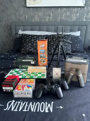 a pile of books and a camera on a bed at Azure Urban Resort Residences in Manila