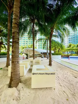 a park with palm trees and benches on the beach at Azure Urban Resort Residences in Manila