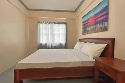 a small bedroom with a bed with a window at Lawton Residences Studio Room 2D in Manila