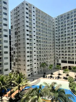 a view of two large buildings with palm trees at Shore Residences - 1 Bedroom Condo Unit in Manila