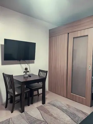 a dining room with a table and two chairs and a television at Shore Residences - 1 Bedroom Condo Unit in Manila