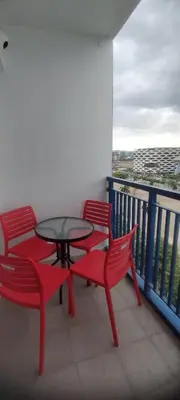 two red chairs and a table on a balcony at Derick Staycation With Balcony Moa View in Manila