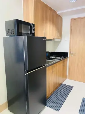 a kitchen with a black refrigerator and a microwave at Sofias Haven - Shore 3 Residences T1 in Manila