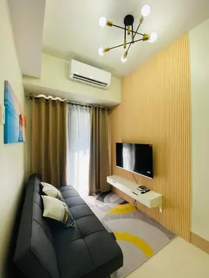 a living room with a couch and a flat screen tv at Sofias Haven - Shore 3 Residences T1 in Manila