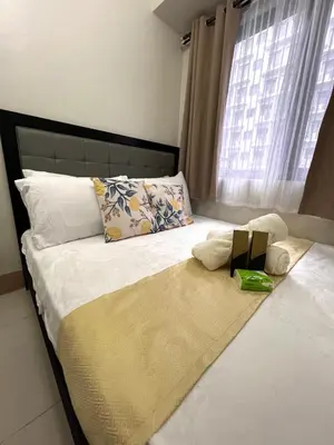a bedroom with a large bed with a large window at Sofias Haven - Shore 3 Residences T1 in Manila