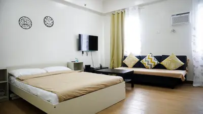 a bedroom with a bed and a couch at Warm & Cozy Retreat near SM City Trece Martires in Trece Martires