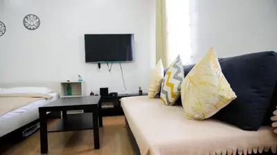 a living room with a couch and a tv at Warm & Cozy Retreat near SM City Trece Martires in Trece Martires