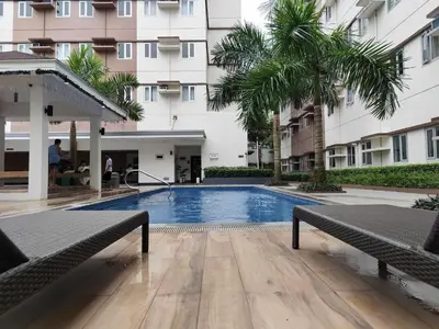 a swimming pool in front of a building at Warm & Cozy Retreat near SM City Trece Martires in Trece Martires