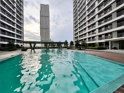 a large pool of water with two tall buildings at Ortigas Greenfield Cozy Lodge in Manila