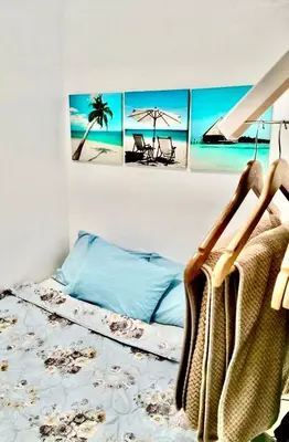 a bedroom with a bed with four paintings on the wall at Ortigas Greenfield Cozy Lodge in Manila