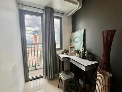 a home office with a desk and a large window at SMDC FAME apartment in Ortigas in Manila