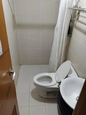 a small bathroom with a toilet and a sink at Heart of Ortigas Center in Manila