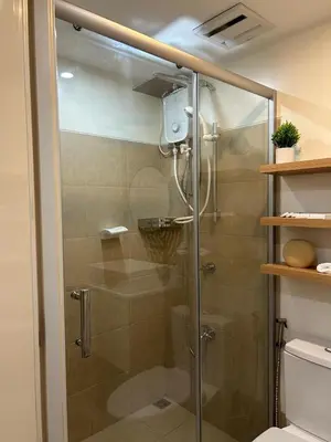 a shower with a glass door in a bathroom at A Scandinavian-inspired studio in Silang in Bayabasan