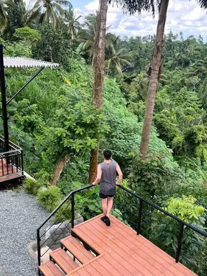 a man walking down a wooden walkway in a forest at Villa Teodora in Biñan