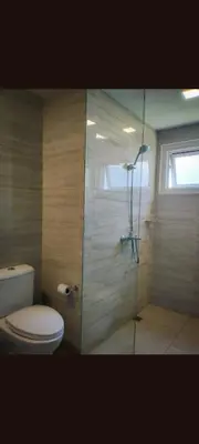a bathroom with a toilet and a glass shower at One Winstar Realty Corp in Manila
