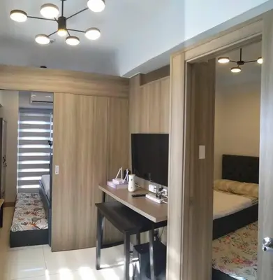 a room with a desk and a bedroom with a bed at Condo next door in Manila