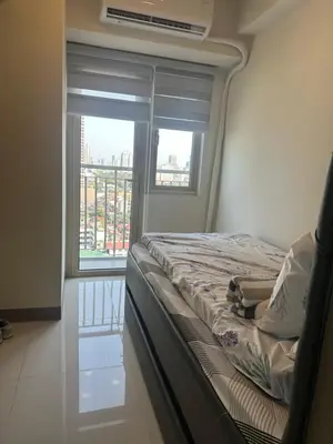 a bed in a room with a large window at Condo next door in Manila
