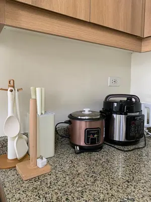 a kitchen counter with a slow cooker and a toaster at Fairlane Residences in Manila
