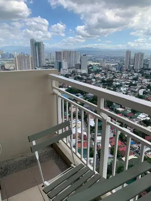 a bench sitting on top of a balcony with a city at Fairlane Residences in Manila