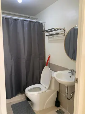 a bathroom with a toilet and a sink at Fairlane Residences in Manila
