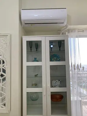 a white cabinet with glass doors and a ceiling at Fairlane Residences in Manila