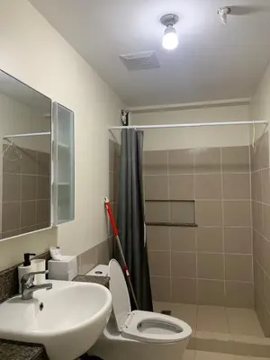 a bathroom with a sink and a toilet and a shower at Fairlane Residences in Manila
