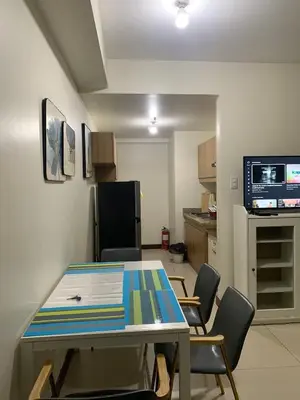 a room with a table and chairs and a kitchen at Fairlane Residences in Manila