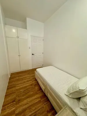 a bedroom with a bed and white walls and wooden floors at Casa Leonardo-Bel Air 4 in Santa Rosa