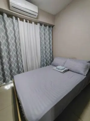 a bed in a room with a window and a mattressvisor at Near MOA at SHORE RESIDENCES 1BR with balcony -unlimited WIFI in Manila