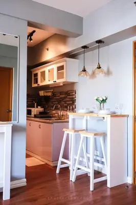 a kitchen with white counters and white stools at Best Deal! Cozy and Minimalist 2BR nr Airport in Manila