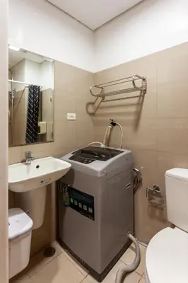 a bathroom with a sink and a washing machine at Shore Residences Tower D - Two Bedroom with Balcony in Manila