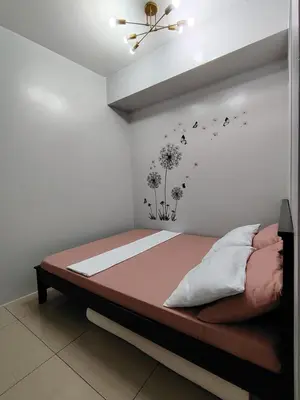 a bedroom with a bed with dandelions and birds on the wall at Shore Residences Tower D - Two Bedroom with Balcony in Manila