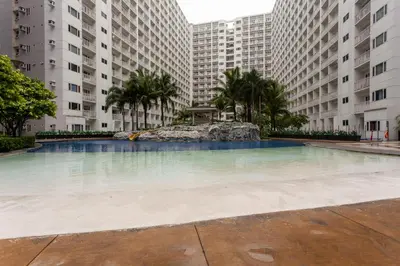 an empty swimming pool in a building with tall buildings at Shore Residences Tower D - Two Bedroom with Balcony in Manila