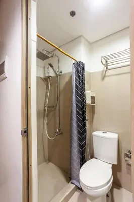a bathroom with a toilet and a shower at Shore Residences Tower D - Two Bedroom with Balcony in Manila