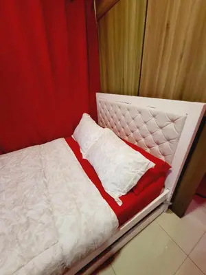 a white bed with red and white pillows on it at Mavic Staycation in Manila