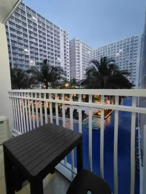 a balcony with a bench and a view of the ocean at Shore Residences - 1 Bedroom with Balcony in Manila