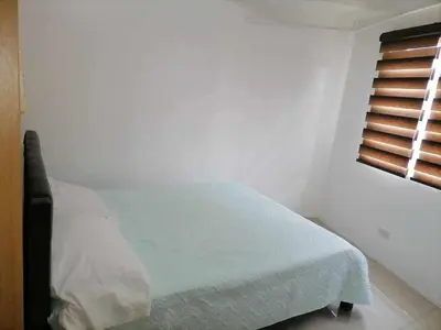 a white bedroom with a bed and a window at spacious 1 br fully furnished condo in Manila
