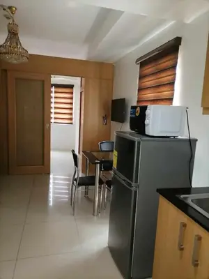 a kitchen with a refrigerator and a table with chairs at spacious 1 br fully furnished condo in Manila