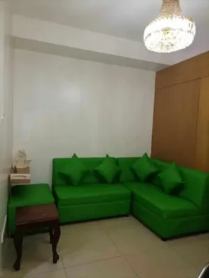 a green couch in a living room with a table at spacious 1 br fully furnished condo in Manila