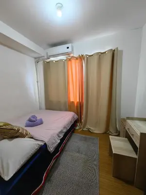 a small room with a bed and curtains at VM Staycation Grace Residence Taguig in Manila
