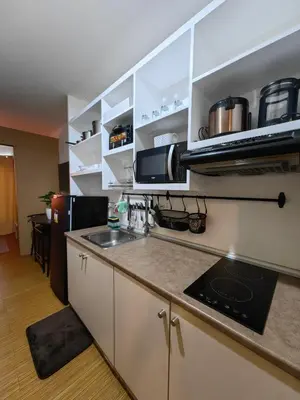 a kitchen with a sink and a microwave at VM Staycation Grace Residence Taguig in Manila
