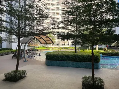 a park with trees in front of a building at VM Staycation Grace Residence Taguig in Manila