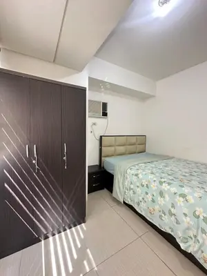 a bedroom with a bed and a large closet at 2br shore residences staycation in Manila