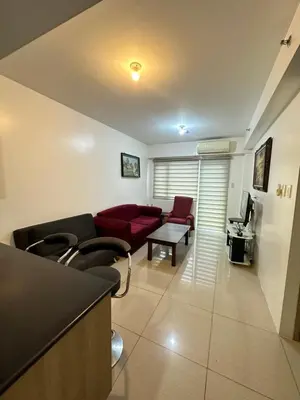 a living room with a couch and a table at 2br shore residences staycation in Manila
